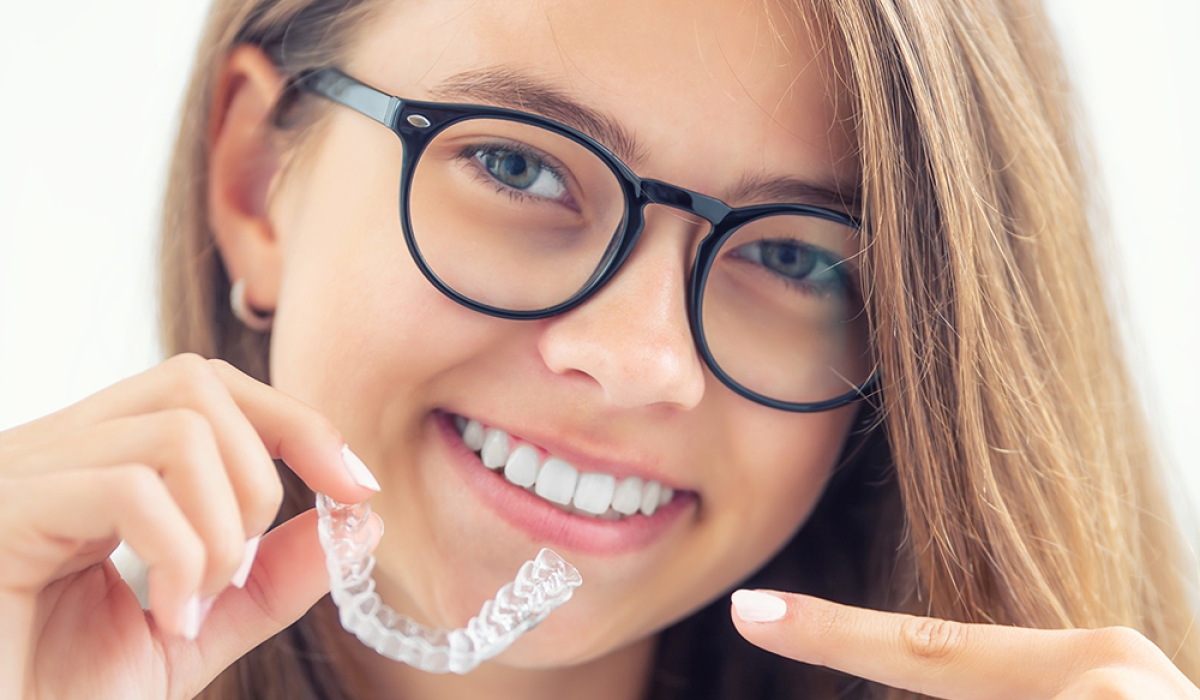 dental-invisible-braces-silicone-trainer-hands-young-smiling-girl-orthodontic-concept-invisalign